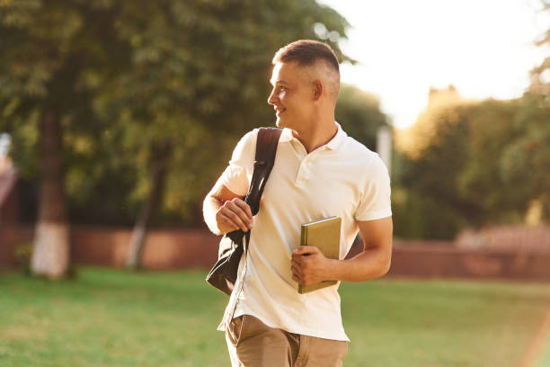 istock With backpack. Young male student is outdoors 2163564676