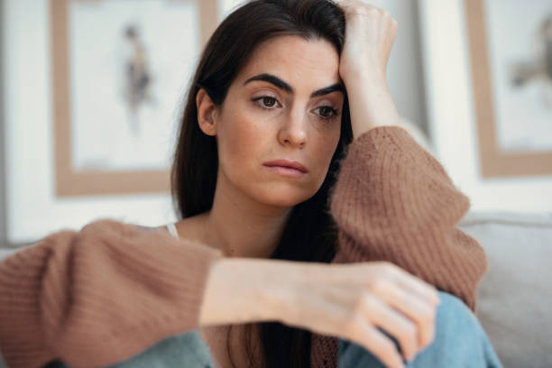istock Depressed young woman overthinking while sitting on the couch at home 2163567216