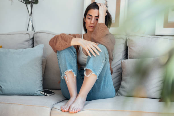 istock Depressed young woman overthinking while sitting on the couch at home 2163567296