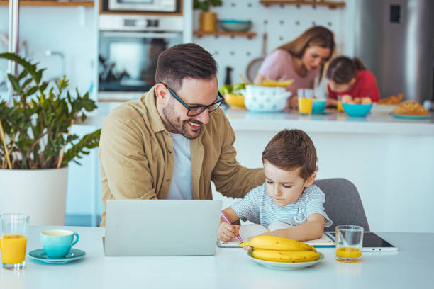 istock Father and Son Engage in Learning with Laptop at Home 2163573846