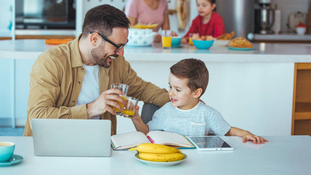 istock Caucasian Dad and Young Son Browsing Laptop at Home 2163573874