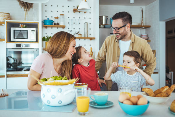 istock Joyful Family Engages in Breakfast Prep in Sunlit Kitchen 2163573955