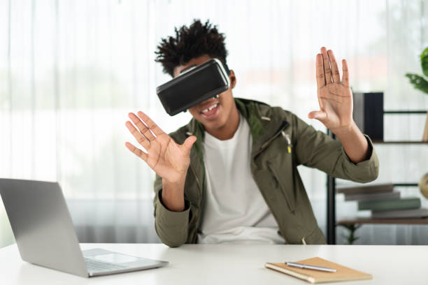 istock African American looking through VR pointing zoom for data online. Contrivance. 2163575550