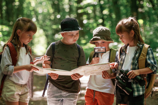 istock Checking the way on the map. Kids in forest at summer daytime together 2163576347