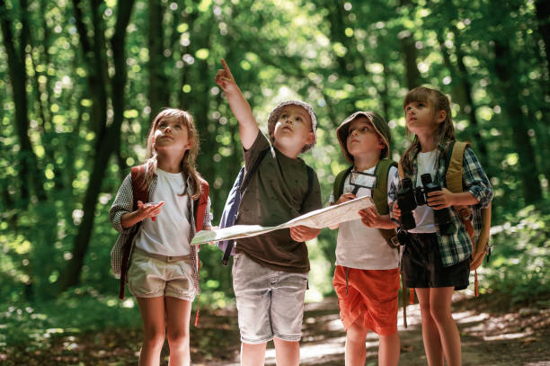 istock Checking the way on the map. Kids in forest at summer daytime together 2163576353