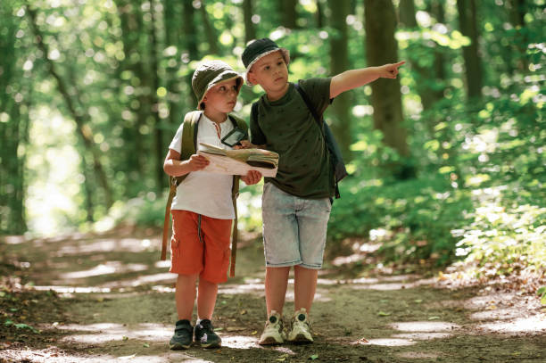 istock Looking for the way. Kids in forest at summer daytime together 2163576384