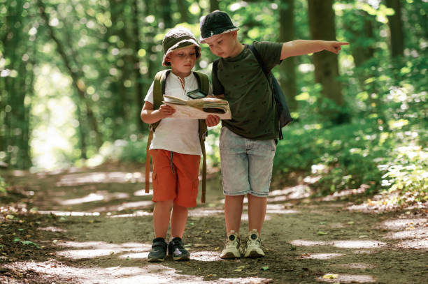 istock Looking for the way. Kids in forest at summer daytime together 2163576391