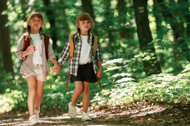 istock Front view. Kids in forest at summer daytime together 2163576409