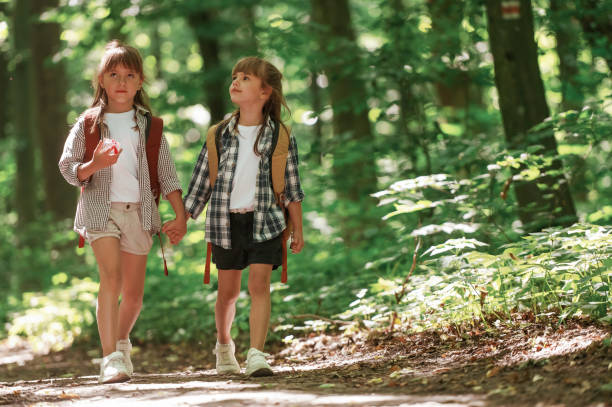 istock Front view. Kids in forest at summer daytime together 2163576412