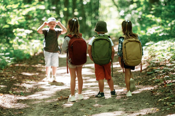 istock View from the back. Kids in forest at summer daytime together 2163576426