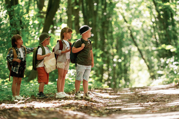 istock Going to the side. Kids in forest at summer daytime together 2163576504