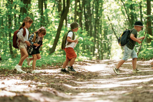istock Weekend hiking. Kids in forest at summer daytime together 2163576577