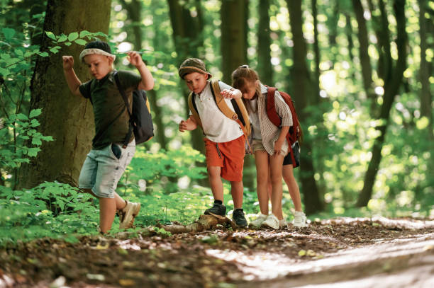 istock Going on the pathway. Kids in forest at summer daytime together 2163576643
