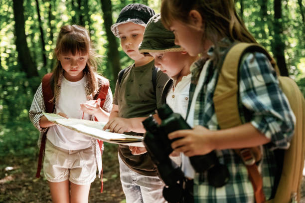 istock Looking at the map. Kids in forest at summer daytime together 2163576666