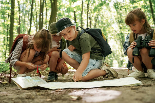 istock On the ground with map. Kids in forest at summer daytime together 2163576729