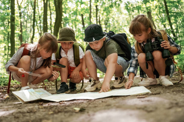 istock On the ground with map. Kids in forest at summer daytime together 2163576740