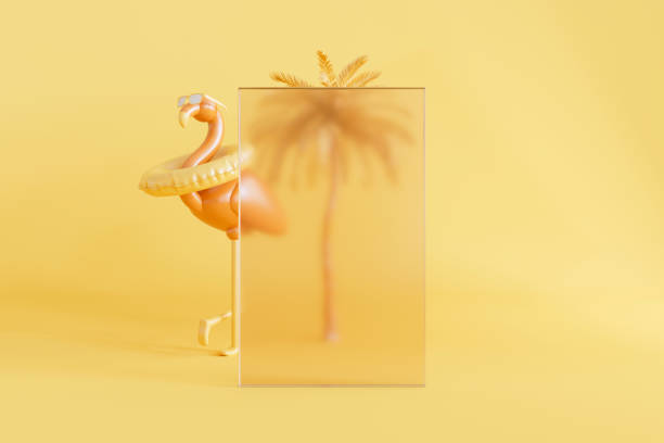 istock Inflatable flamingo and palm tree behind glass frame on yellow summer background 2163576764
