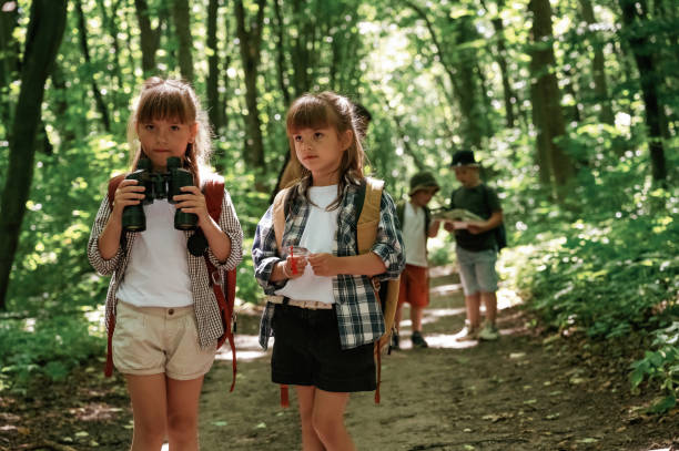 istock Using binoculars. Kids in forest at summer daytime together 2163576781