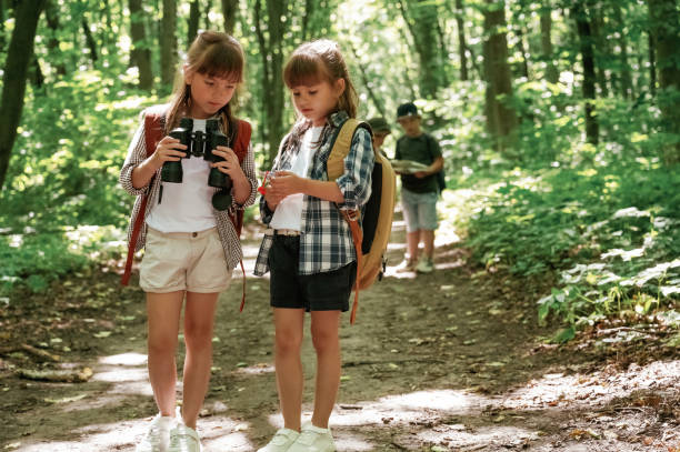 istock Using binoculars. Kids in forest at summer daytime together 2163576794