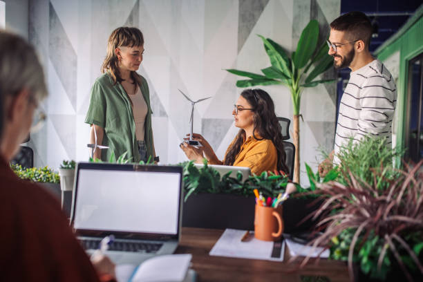 istock Team discussing project with eco-friendly wind turbine. 2163578405