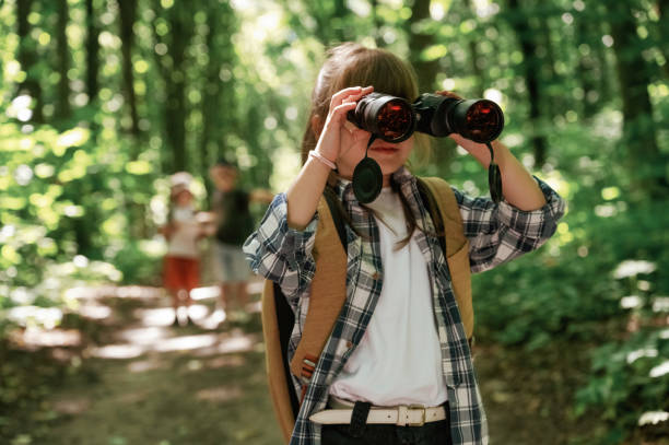 istock Binoculars in hands. Kids in forest at summer daytime together 2163581625