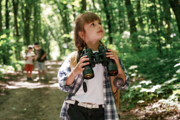 istock Binoculars in hands. Kids in forest at summer daytime together 2163581629