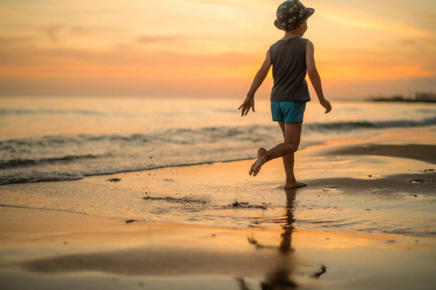 Child running on the beach in sunset