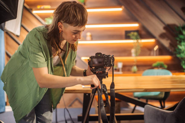 istock Woman adjusting camera setup in a well-decorated studio. 2163584955