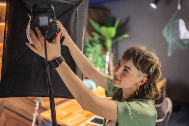 istock Woman setting up lighting in studio with plants around 2163586971
