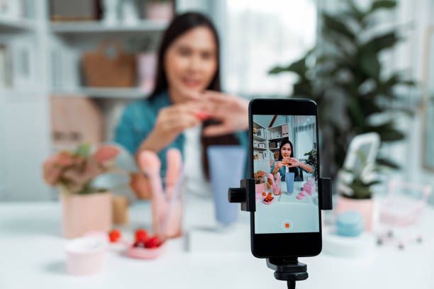 istock Selective focus phone with Asian showing cosmetic makeup lipstick. Stratagem. 2163589212