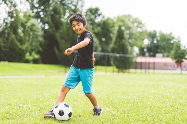 istock nice and handsome child boy play football outside 2163589636