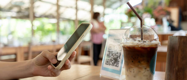 istock Woman use smartphone to scan QR code to pay in cafe restaurant with a digital payment without cash. Choose menu and order accumulate discount. E wallet, technology, pay online, credit card, bank app. 2163595813