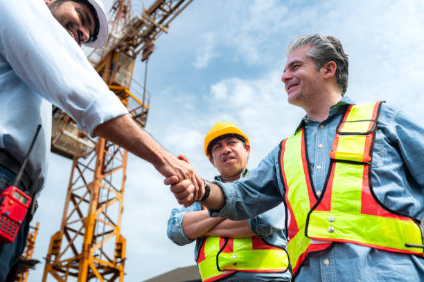 istock Group of workers at construction site are discussing construction progress with a tower crane in the background 2163596047