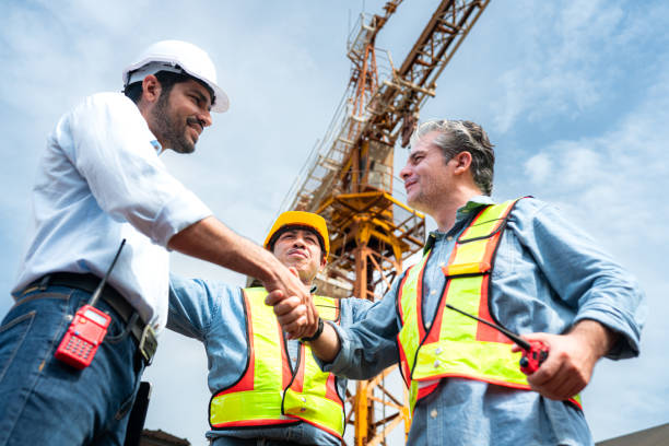 istock Group of workers at construction site are discussing construction progress with a tower crane in the background 2163596142