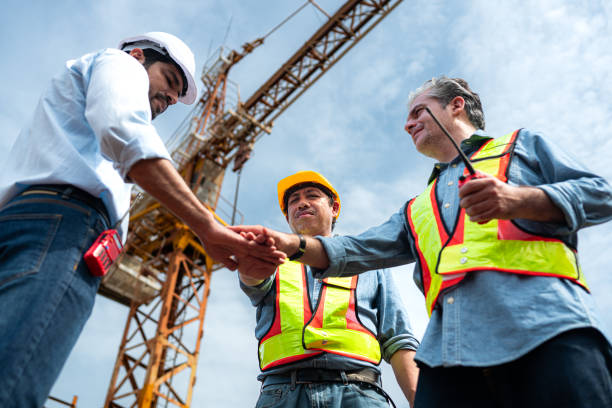 istock Group of workers at construction site are discussing construction progress with a tower crane in the background 2163596147