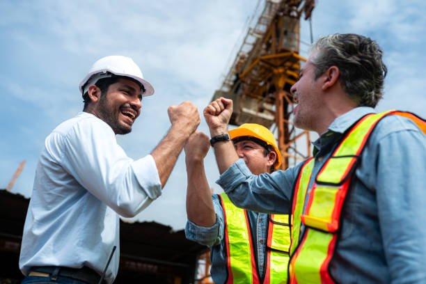 istock Group of workers at construction site are discussing construction progress with a tower crane in the background 2163596148