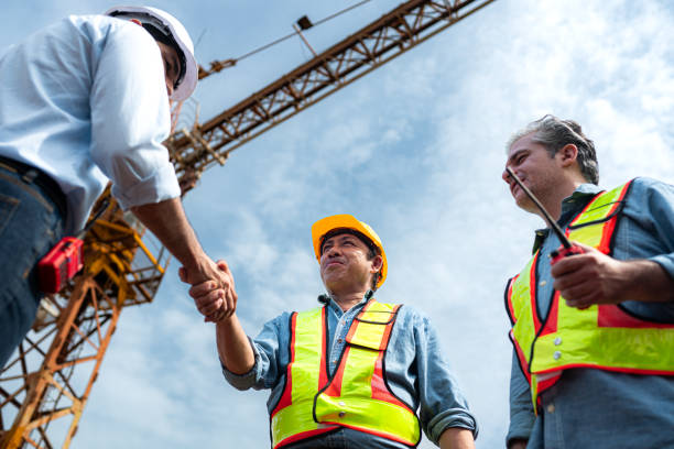 istock Group of workers at construction site are discussing construction progress with a tower crane in the background 2163596150
