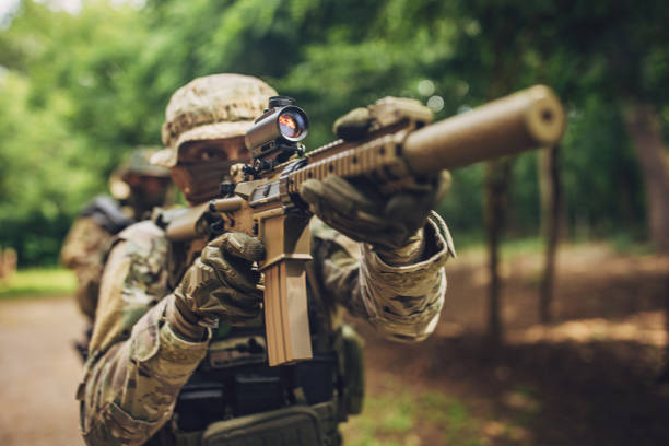 istock Soldier aiming his rifle with tactical precision in woods. 2163598544