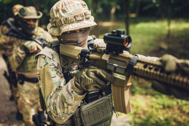 istock Armed soldiers in tactical gear advancing in forest 2163599149