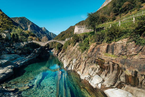istock Scenic Mountain Landscape with Crystal Clear River and Stone Bridge 2163602257