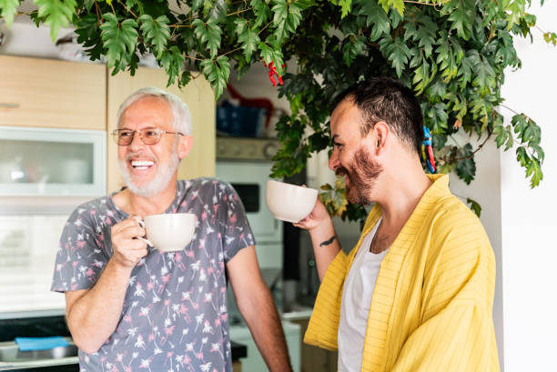 istock Gay couple talking and drinking coffee at home 2163603085