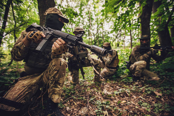 istock Armed soldiers tactically positioned in dense forest 2163604531