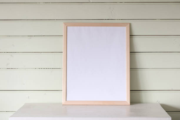 istock large empty frame, a mockup, a stage creator. a white table in the cottage, a light green wooden wall. summer background. 2163608048