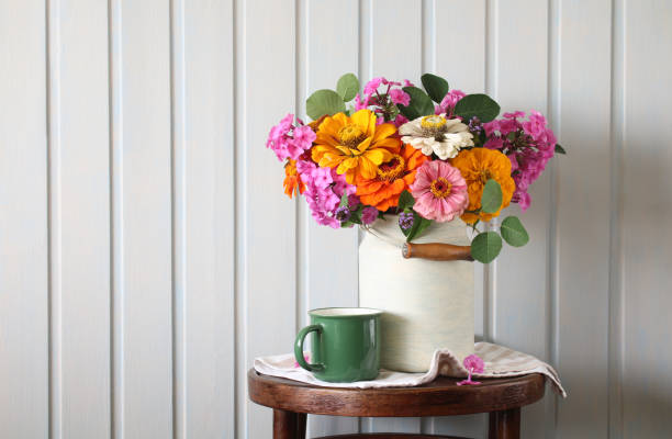 istock garden flowers in a white can on a round table and a mug. copy space. 2163609246