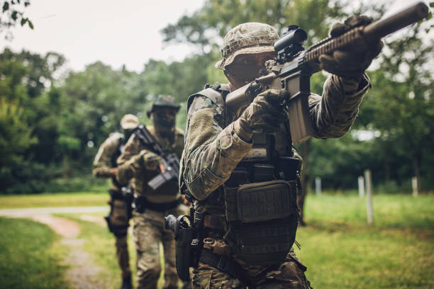 istock Tactical unit moving through forest with military equipment 2163609856