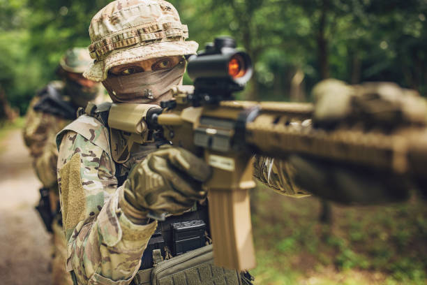 istock Military operation: soldiers aiming rifles in forest 2163611072