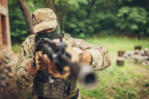 istock Soldier aiming rifle in green forest environment 2163611815
