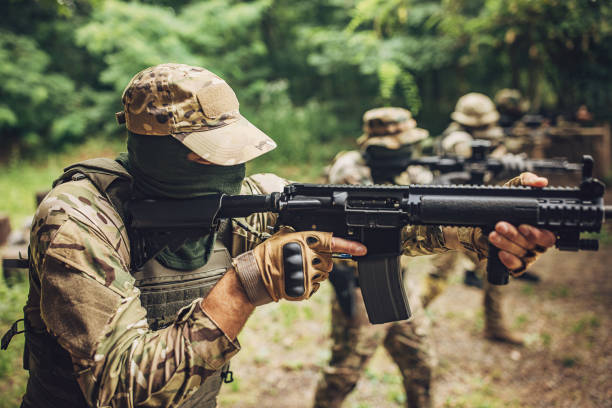 istock Armed soldier aiming rifle at target in forest training. 2163612249