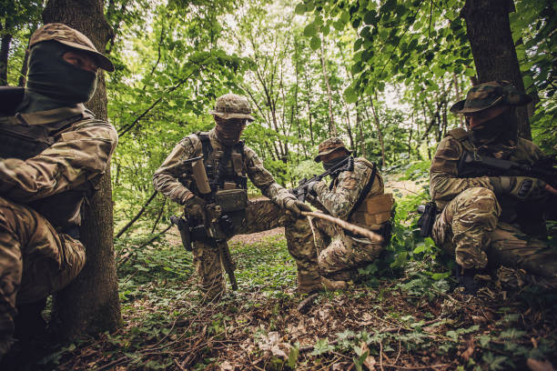 istock Four soldiers in dense forest with tactical gear shown 2163616339