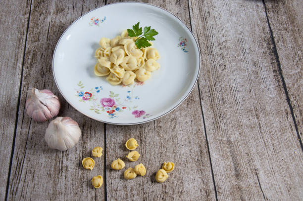 delicious tortellini with garlic on a wooden table